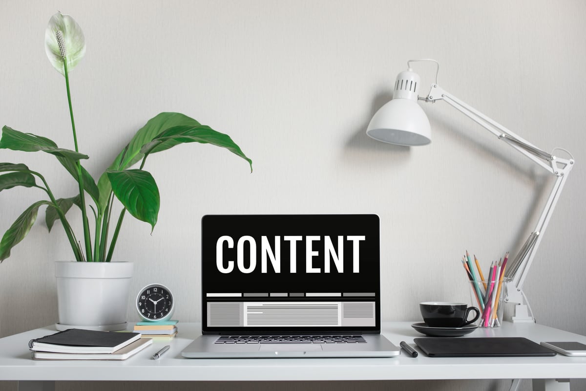 Contents marketing concepts with text on computer laptop and accessories on worktable
